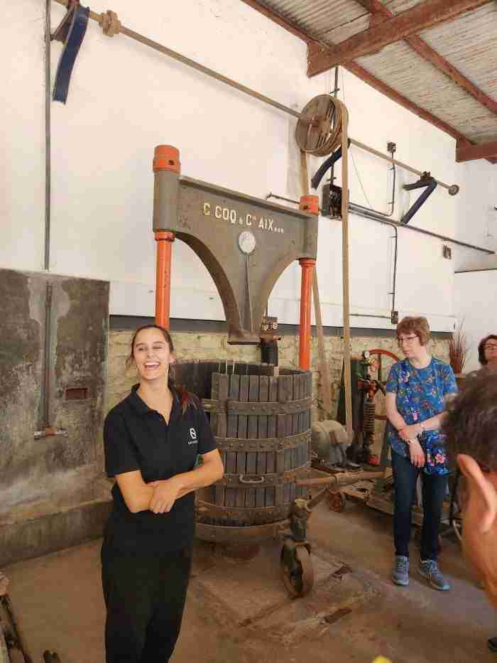 A group of people standing next to a large machine Description automatically generated with low confidence
