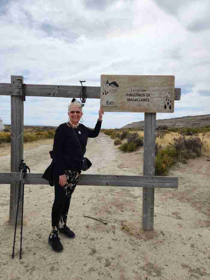 A person standing next to a sign Description automatically generated with medium confidence