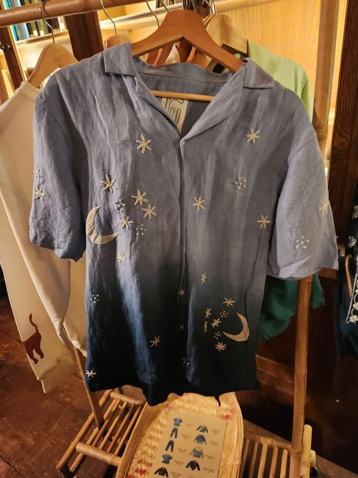 A blue shirt with stars and moon on it Description automatically generated