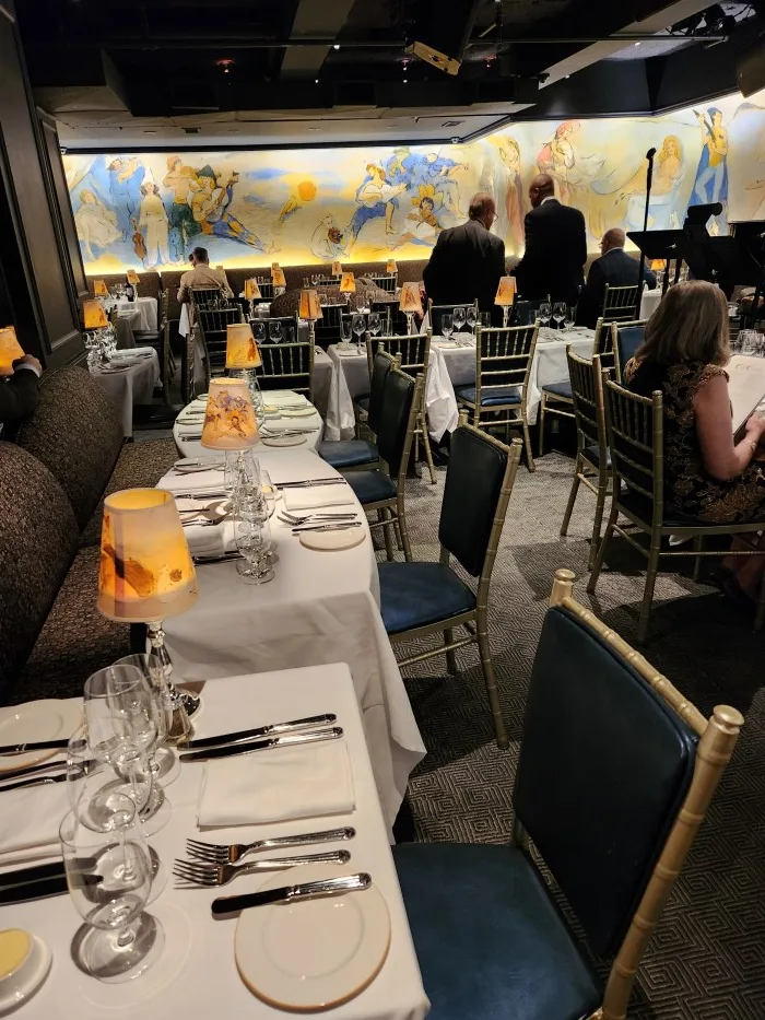 Dining seating and famed murals by French artist Marcel Vertès adorn the walls of Café Carlyle. Photo by Sora Vernikoff