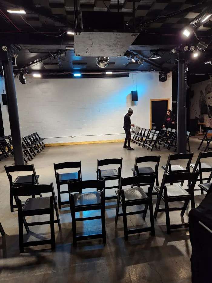 A room with many chairs and a person standing in front of it Description automatically generated