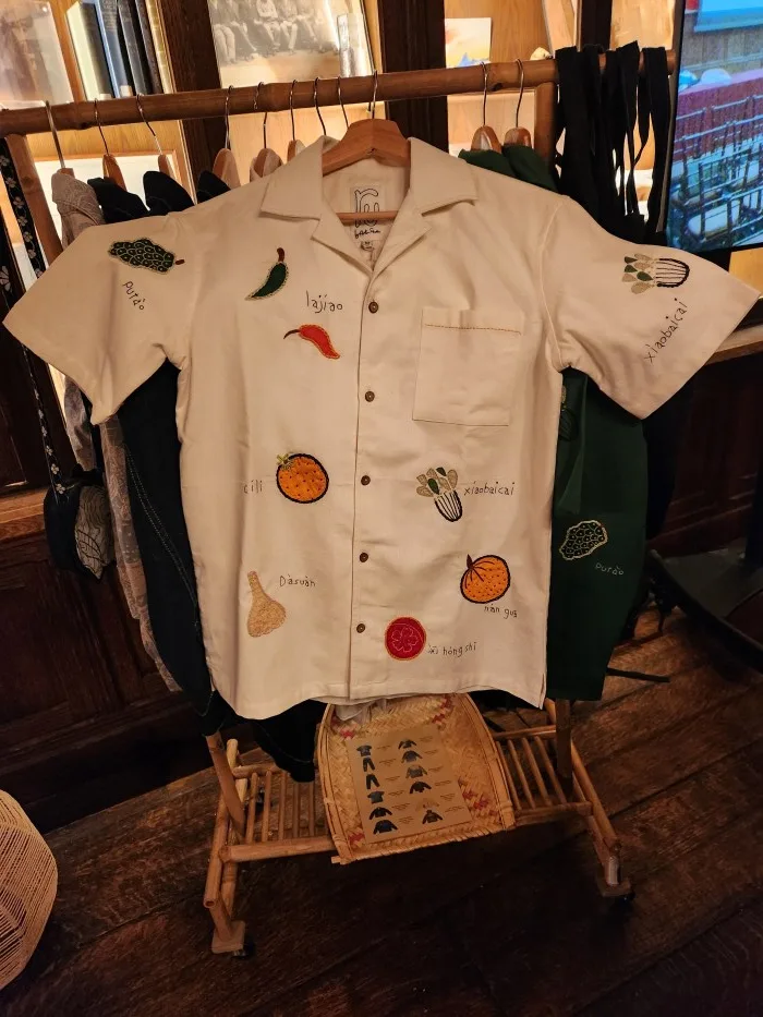 A white shirt with fruit embroidery on it Description automatically generated