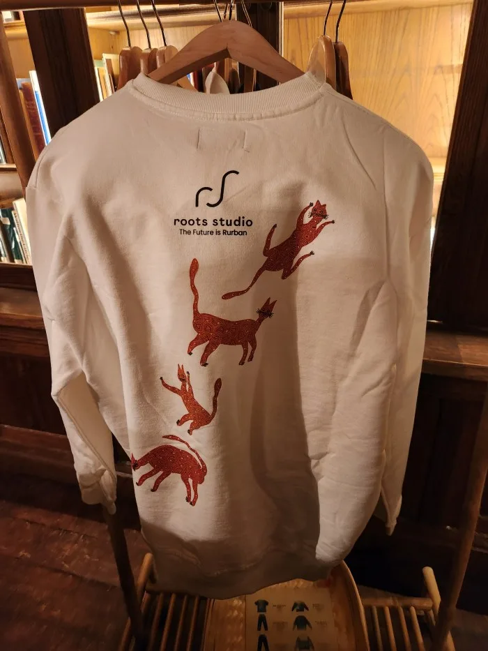 A white shirt with red horses on it Description automatically generated