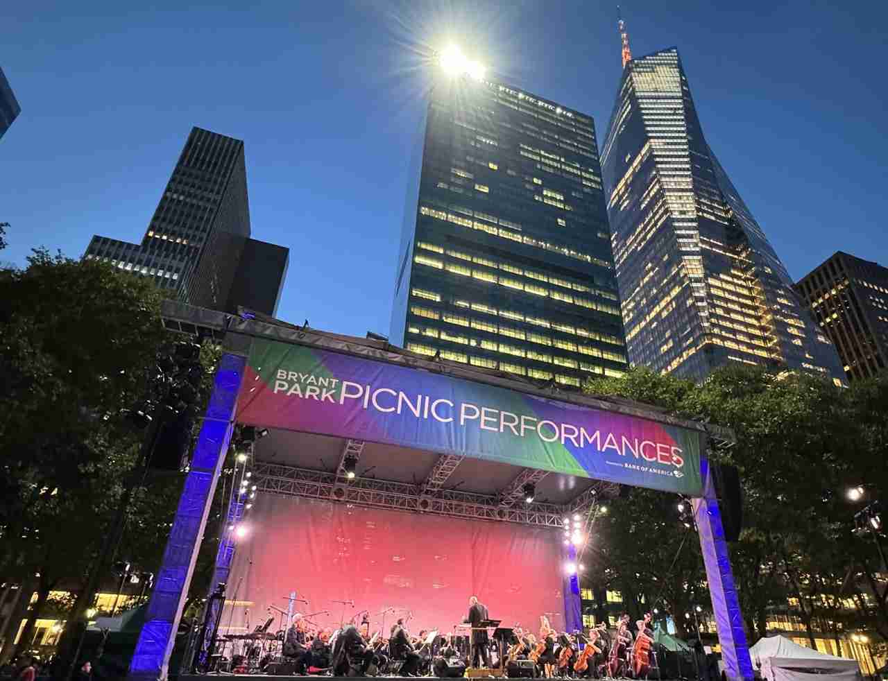 Towering skyscrapers and Leon Botstein conducting Beyond The Hall by the American Symphony Orchestra at Bryant Park. Photo by Edward Kliszus
