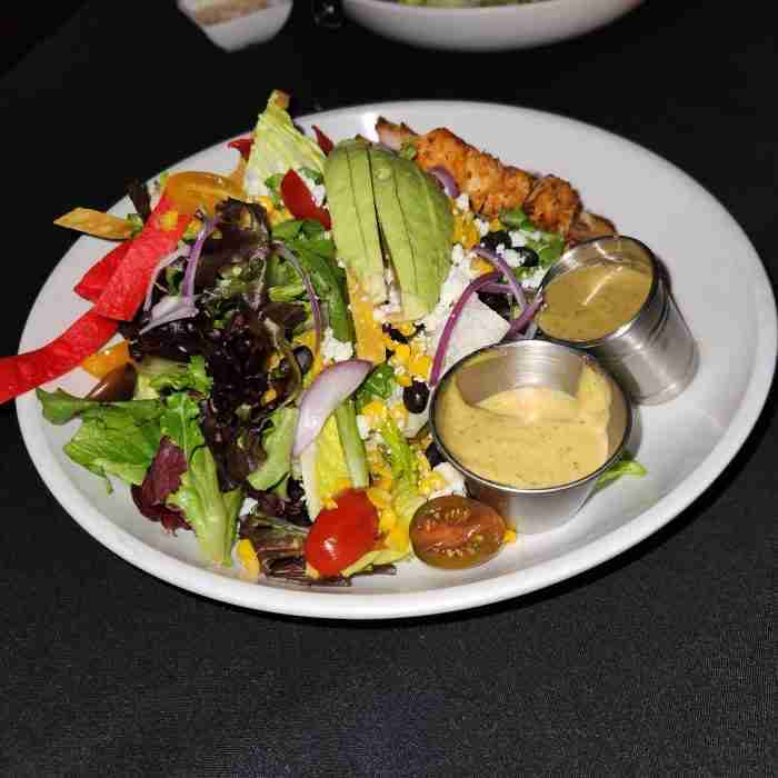 A plate of salad with sauces AI-generated content may be incorrect.