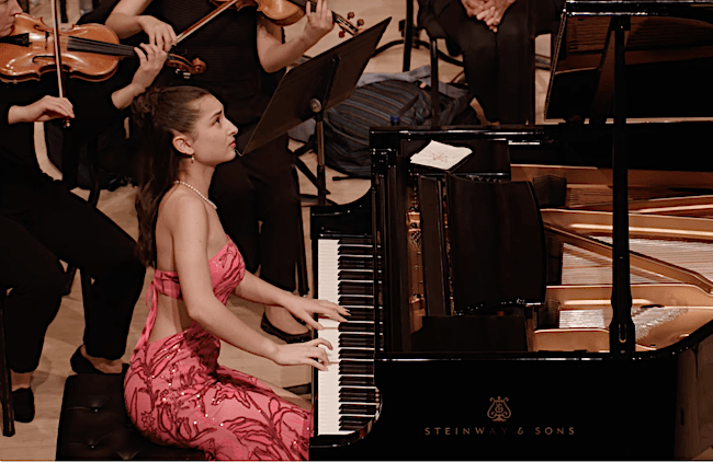Sol Nicholson, Piano, performing with the Park Avenue Chamber Symphony, conducted by David Bernard, in the Kaufman Music Center’s 2025 Special Music High School Concerto Competition Winners' Concert at Merkin Concert Hall, New York City. Screen capture courtesy KaufmanMusicCenter.org