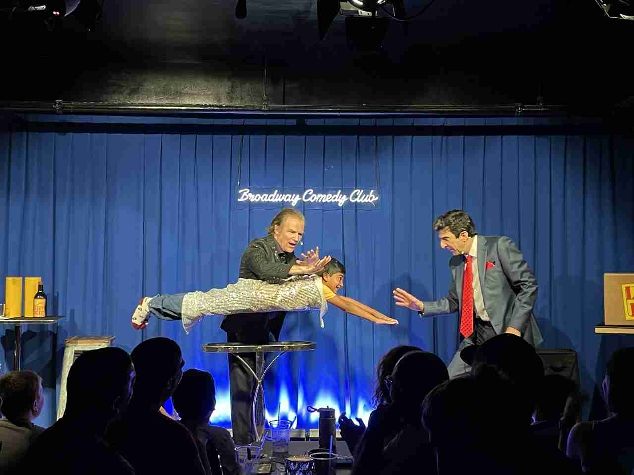Jim Vines and Carl Mecurio performing Levitation with a volunteer in a scene from The Broadway Magic Hour at the Broadway Comedy Club in New York City. Courtesy Michelle Tabnick PR