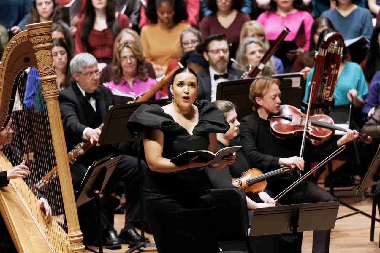 Soloists Mikaela Bennett, soprano, center, The MasterVoices Chorus and Orchestra of St. Luke's. MasterVoices presents Sins and Grace, conceived and conducted by Ted Sperling, Alice Tully Hall, Lincoln Center, Monday, March 23, 2026. Credit Photo: Erin Baiano