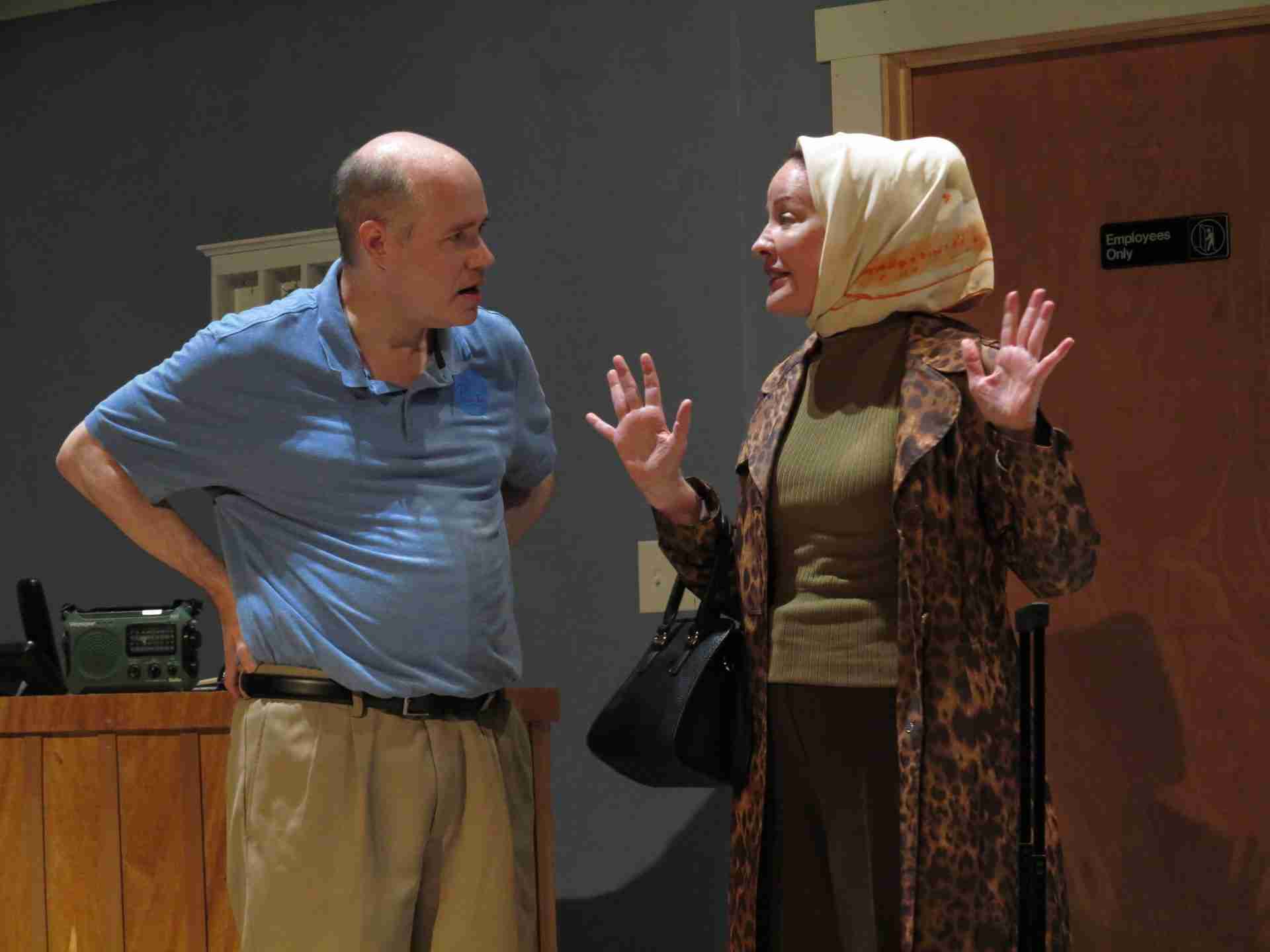 Henry (Mike Roche) resists Heidi Murphy's (Alyssa Simon) attempts to check in during a hurricane in a scene from Henry Feldman's Shelter Inn Place at Theatre Row in NYC. Photo by Jonathan Slaff.